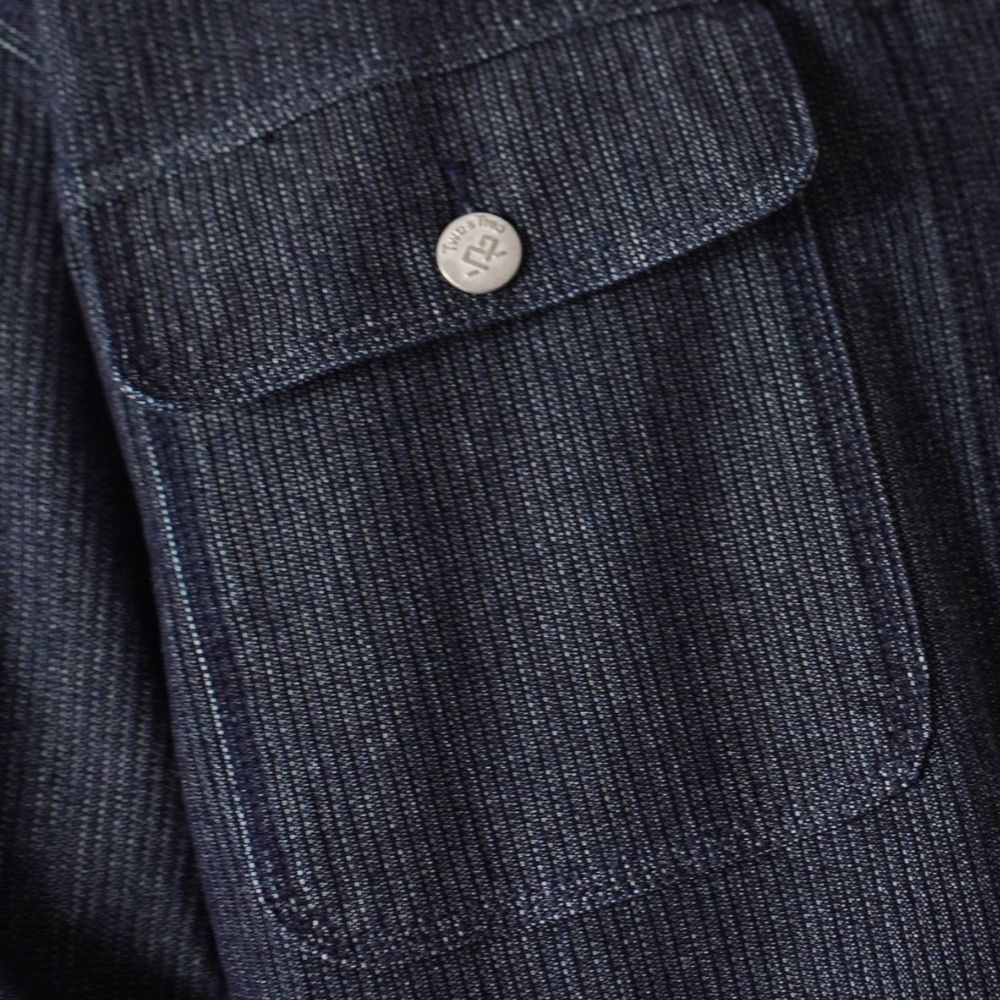 Detalle de etiqueta de cuero Two & Two en jean oscuro